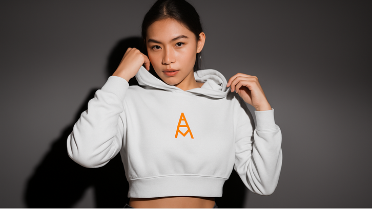 Person wearing a white hoodie with an orange logo on a dark background